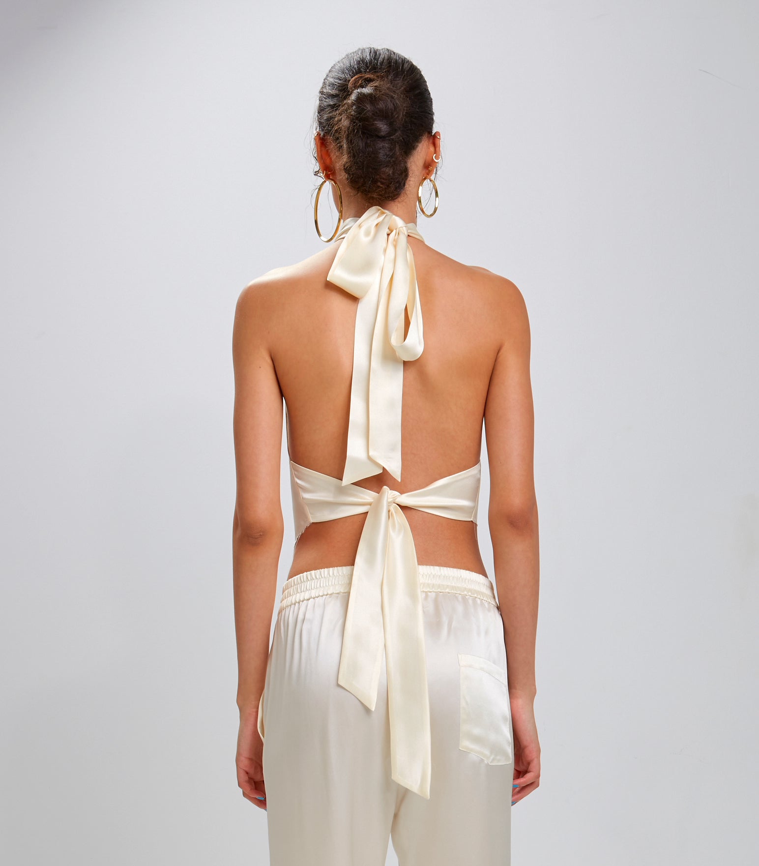 Back view: The Devi Ivory halter tie back 100% Silk Charmeuse top with pointed raw edge